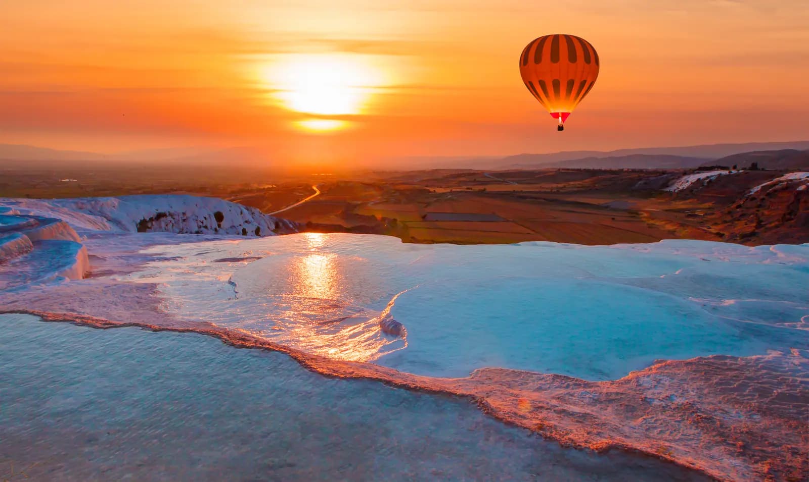Sunset and a hot air balloon over Pamukkale